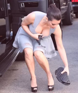 fans get a look at kim kardashian as she bends down to expose her cleavage in a classic downblouse pose