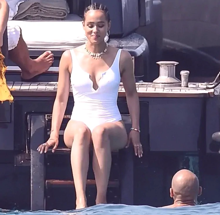 nathalie emmanuel siting on a boat in white swimsuit with cleavage and nipple pokies