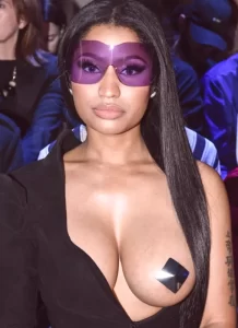 nicki sits topless in the audience at paris fashion show